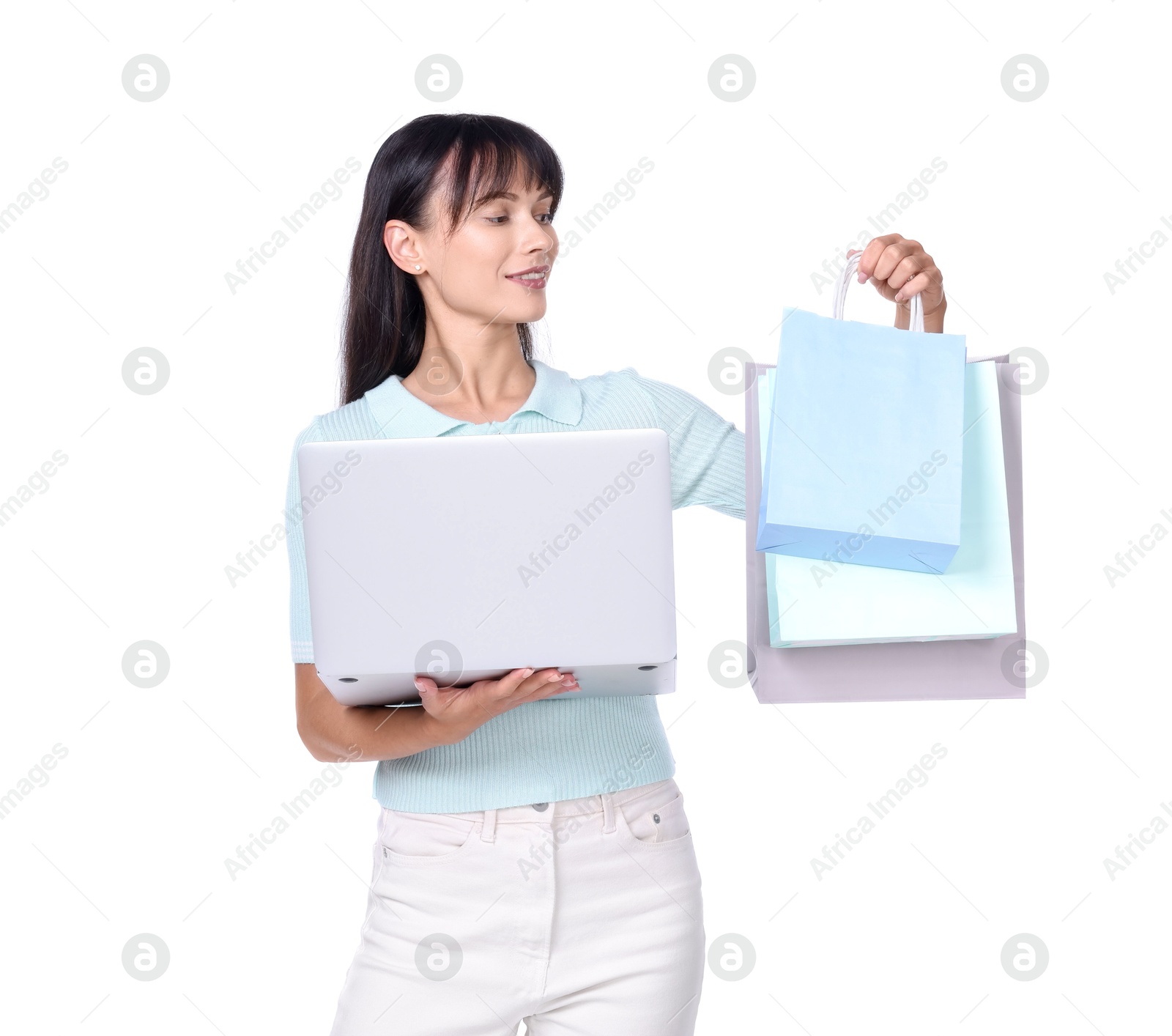 Photo of Internet shopping. Happy woman with laptop and colorful bags on white background