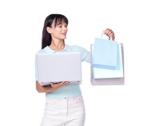 Photo of Internet shopping. Happy woman with laptop and colorful bags on white background