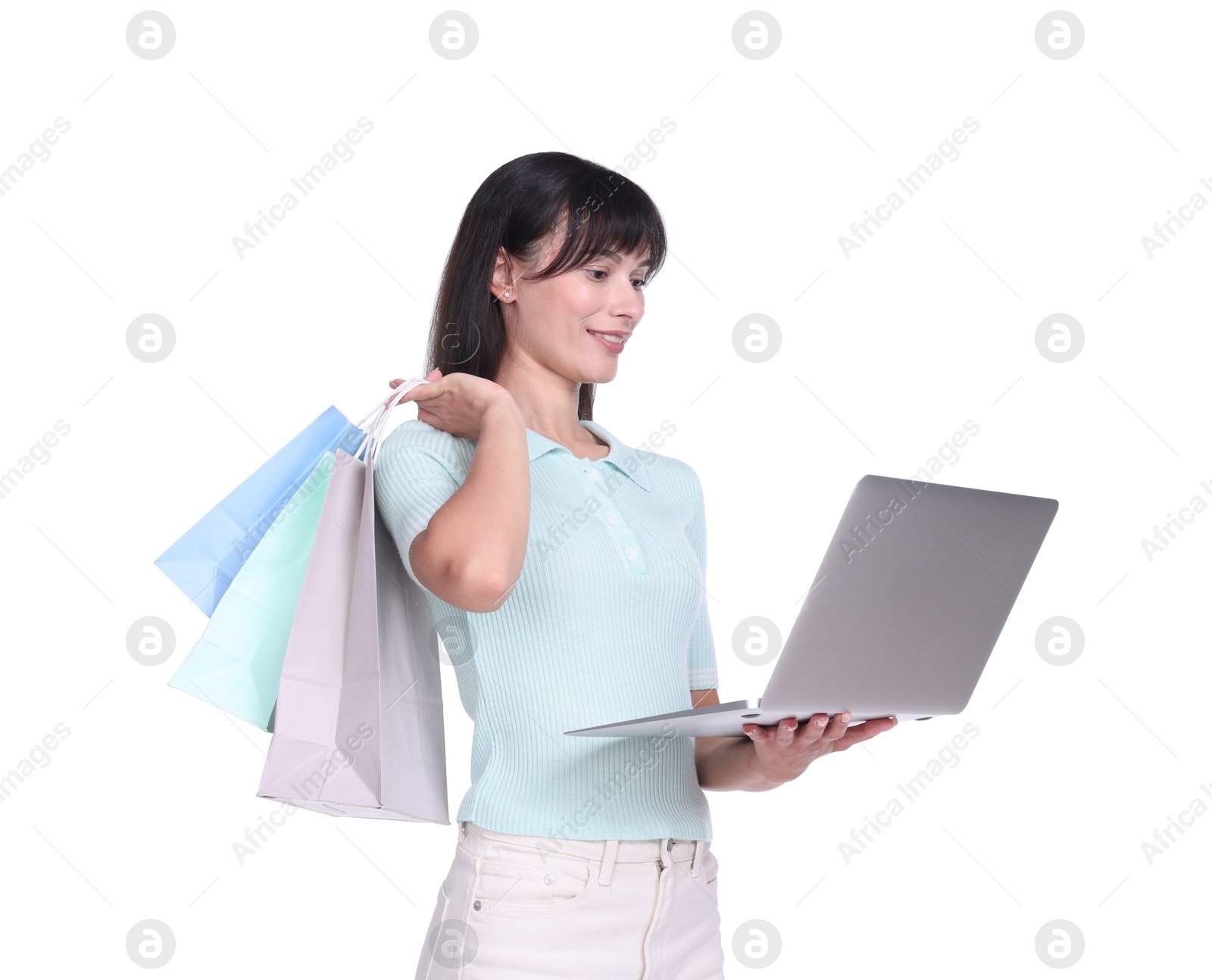 Photo of Internet shopping. Happy woman with laptop and colorful bags on white background