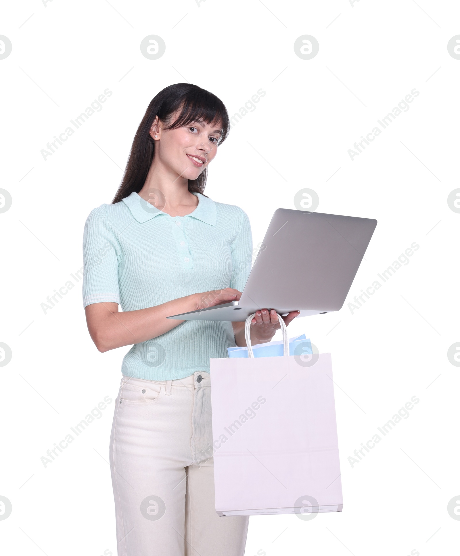 Photo of Internet shopping. Happy woman with laptop and colorful bags on white background