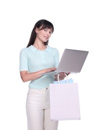 Photo of Internet shopping. Happy woman with laptop and colorful bags on white background