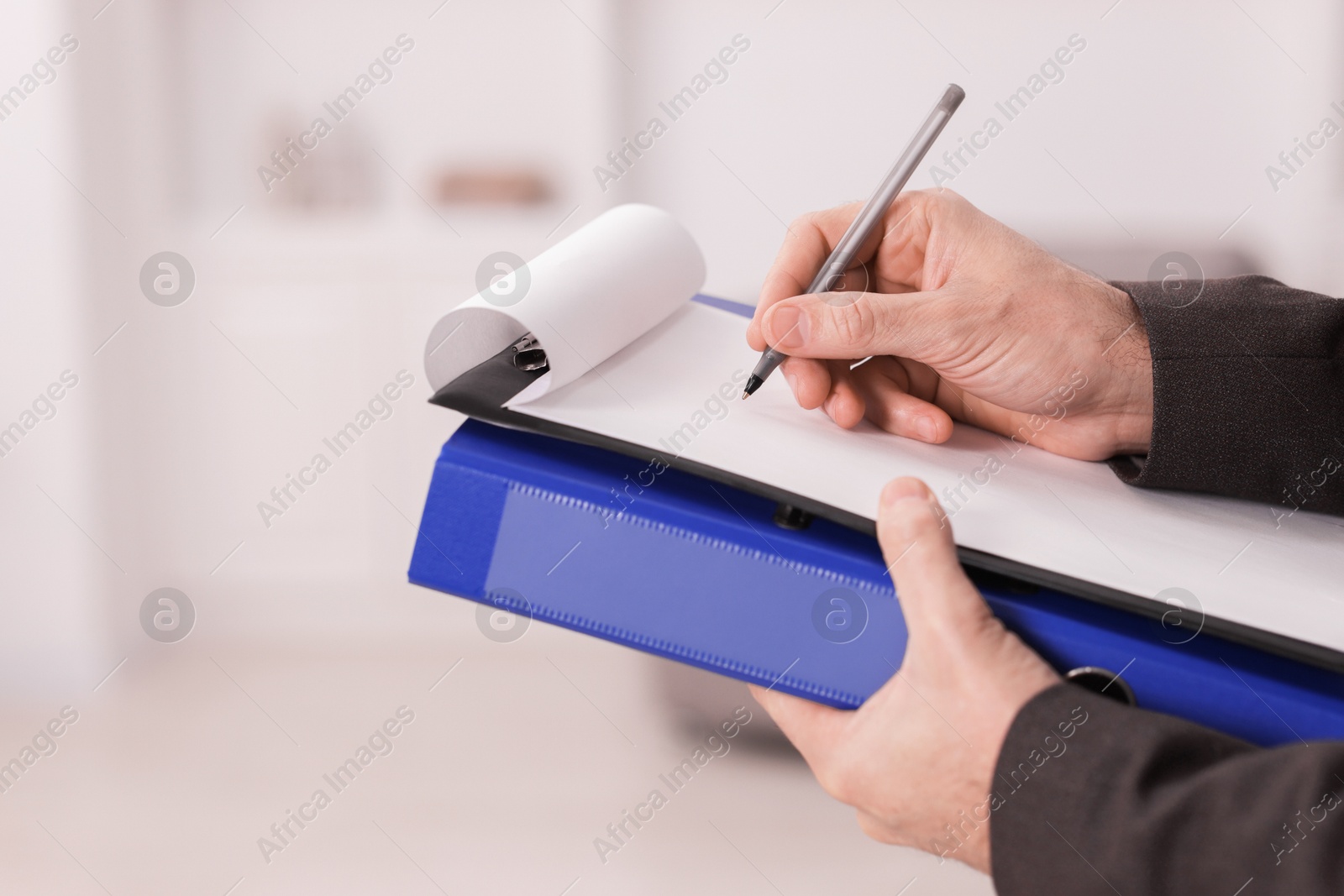 Photo of Real estate appraisal. Inspector with clipboard conducting property valuation indoors, closeup. Space for text