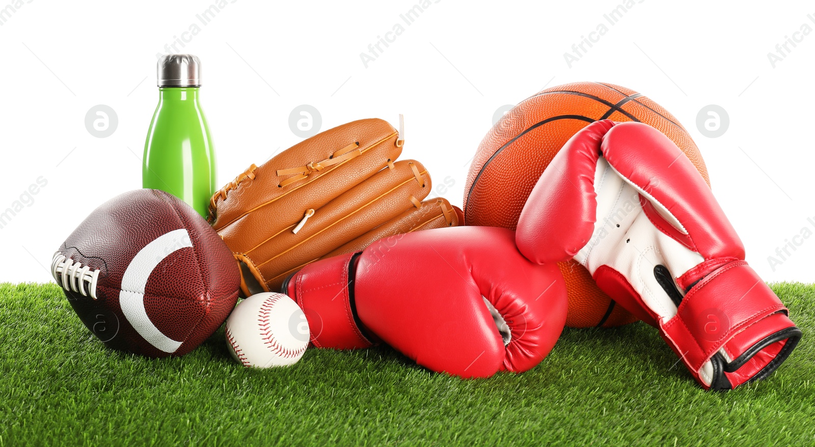 Photo of Different sport equipment on artificial grass isolated on white