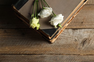 Books and beautiful flowers on wooden table, top view