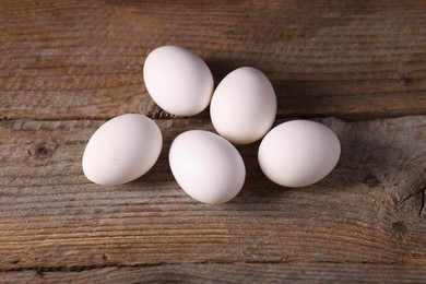 Photo of Many fresh eggs on wooden table, flat lay