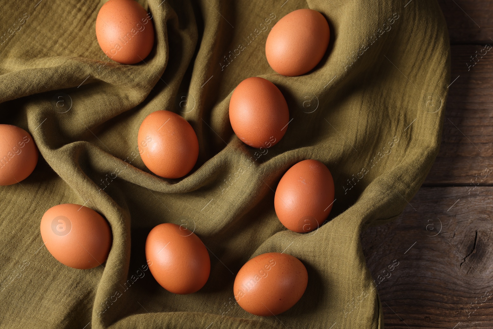 Photo of Many fresh eggs on wooden table, top view