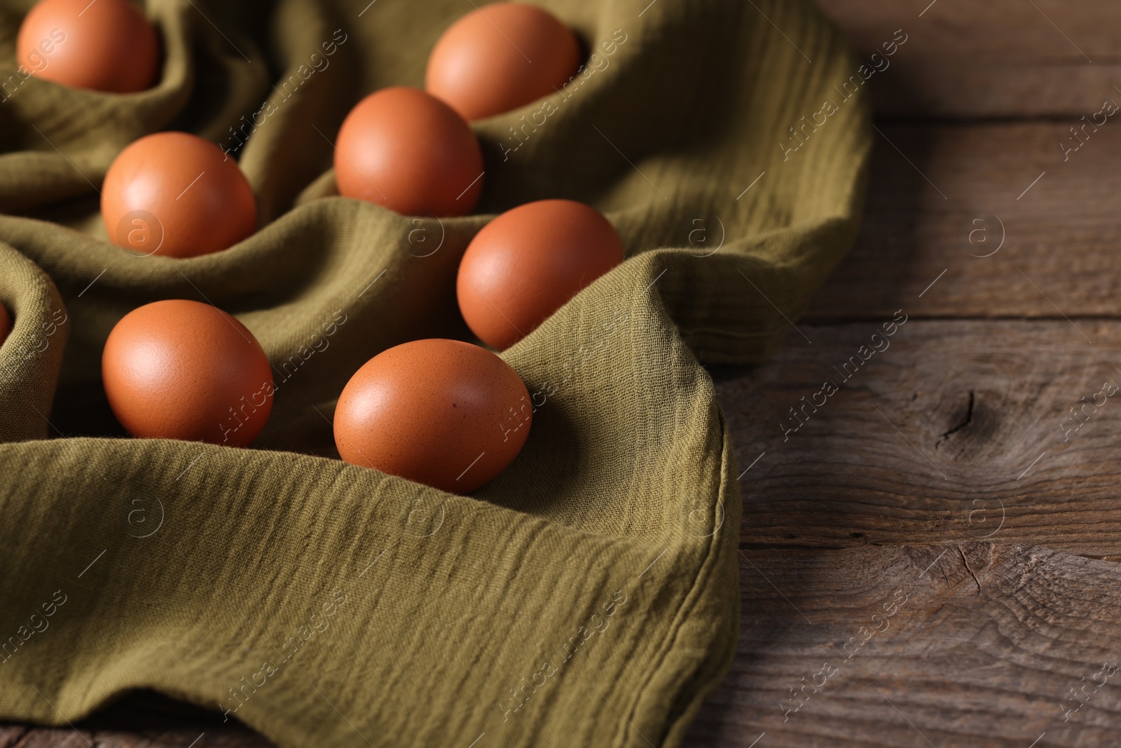 Photo of Many fresh eggs on wooden table, closeup