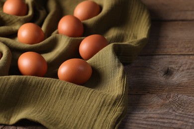 Photo of Many fresh eggs on wooden table, closeup