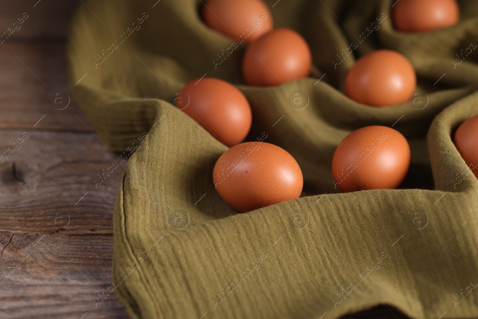 Photo of Many fresh eggs on wooden table, closeup