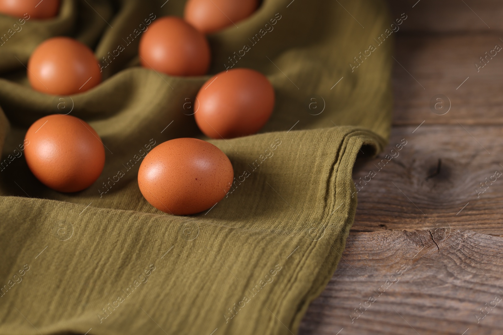 Photo of Many fresh eggs on wooden table, closeup