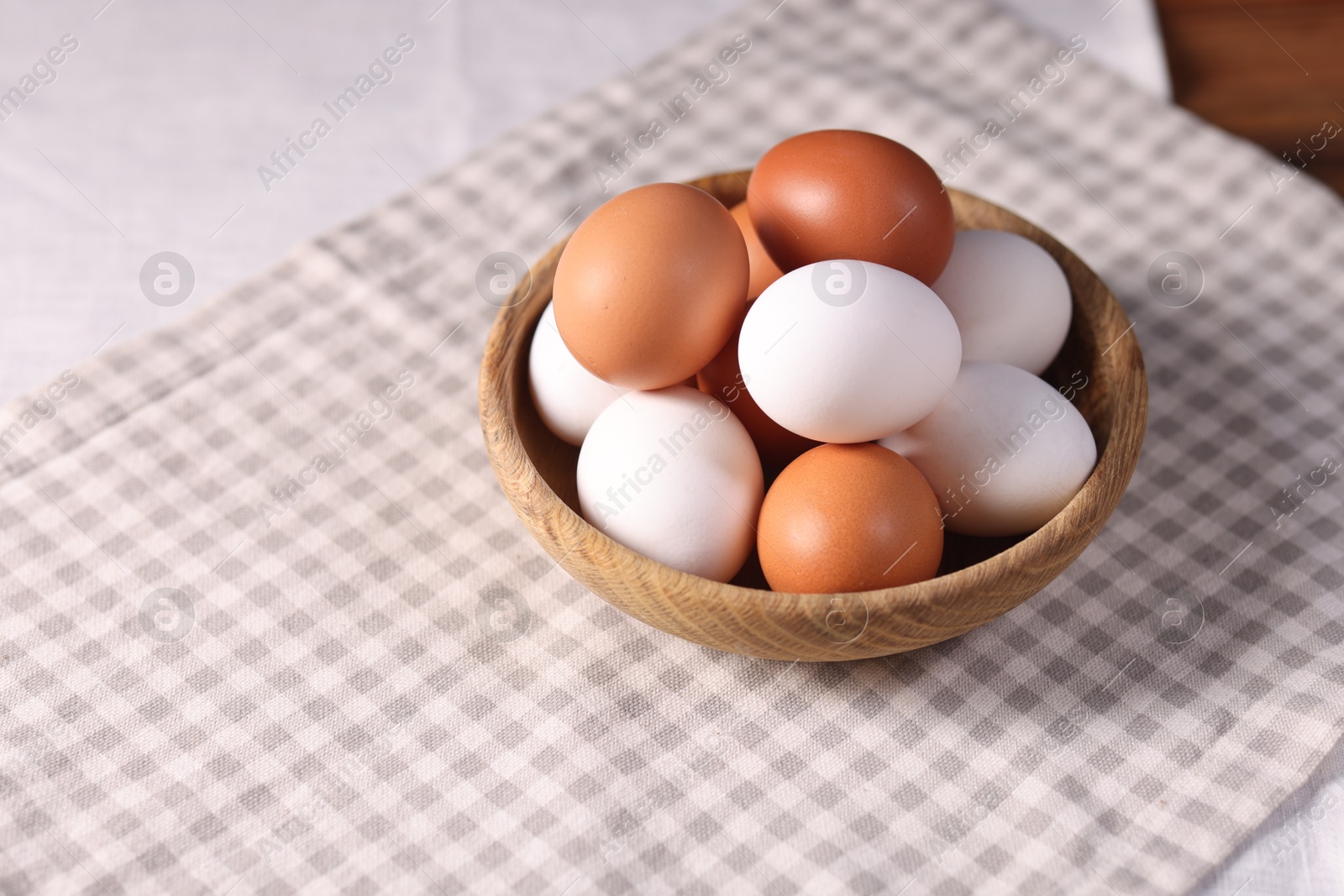 Photo of Fresh eggs in bowl on table, closeup. Space for text