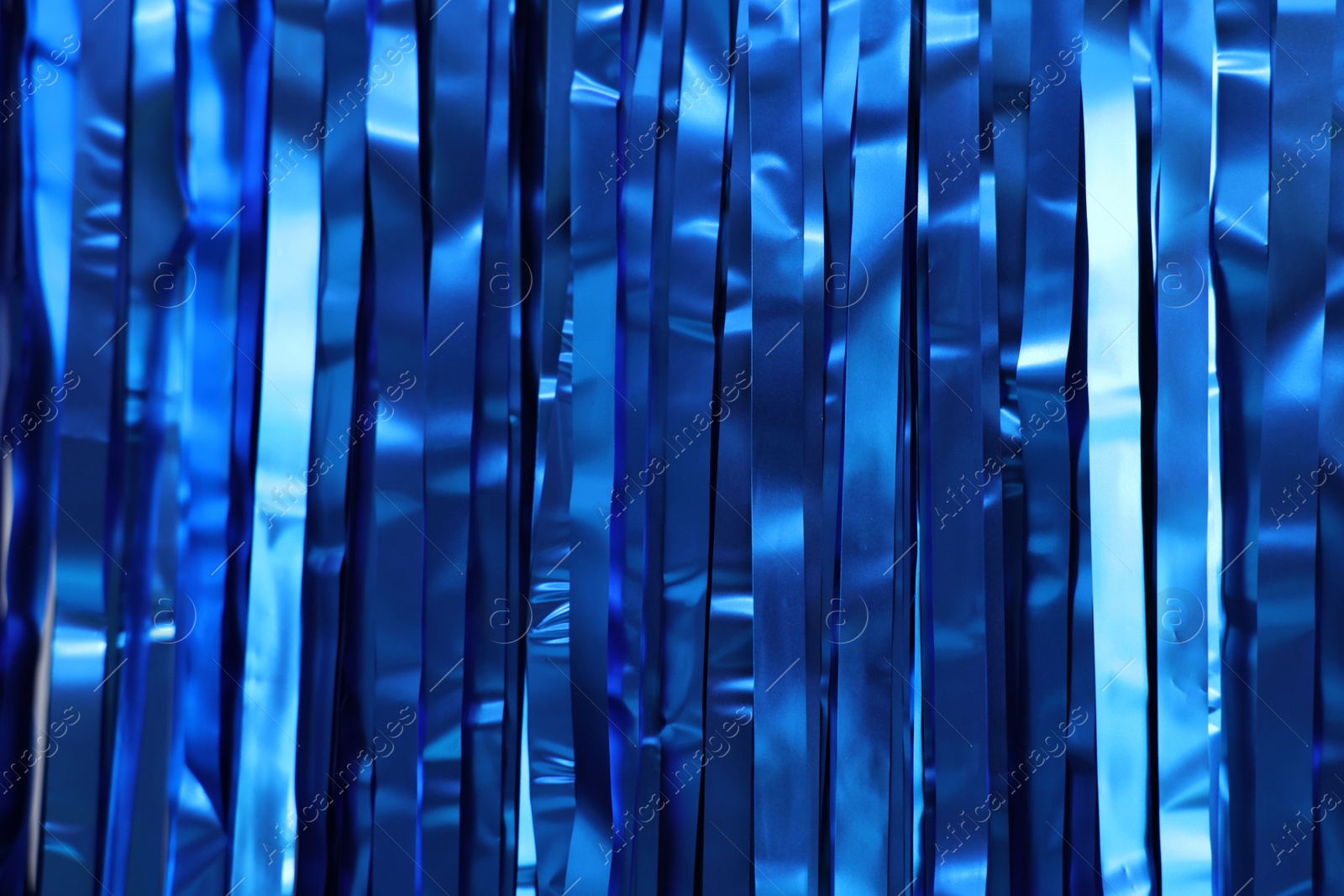 Photo of Shiny blue foil curtain as background, closeup