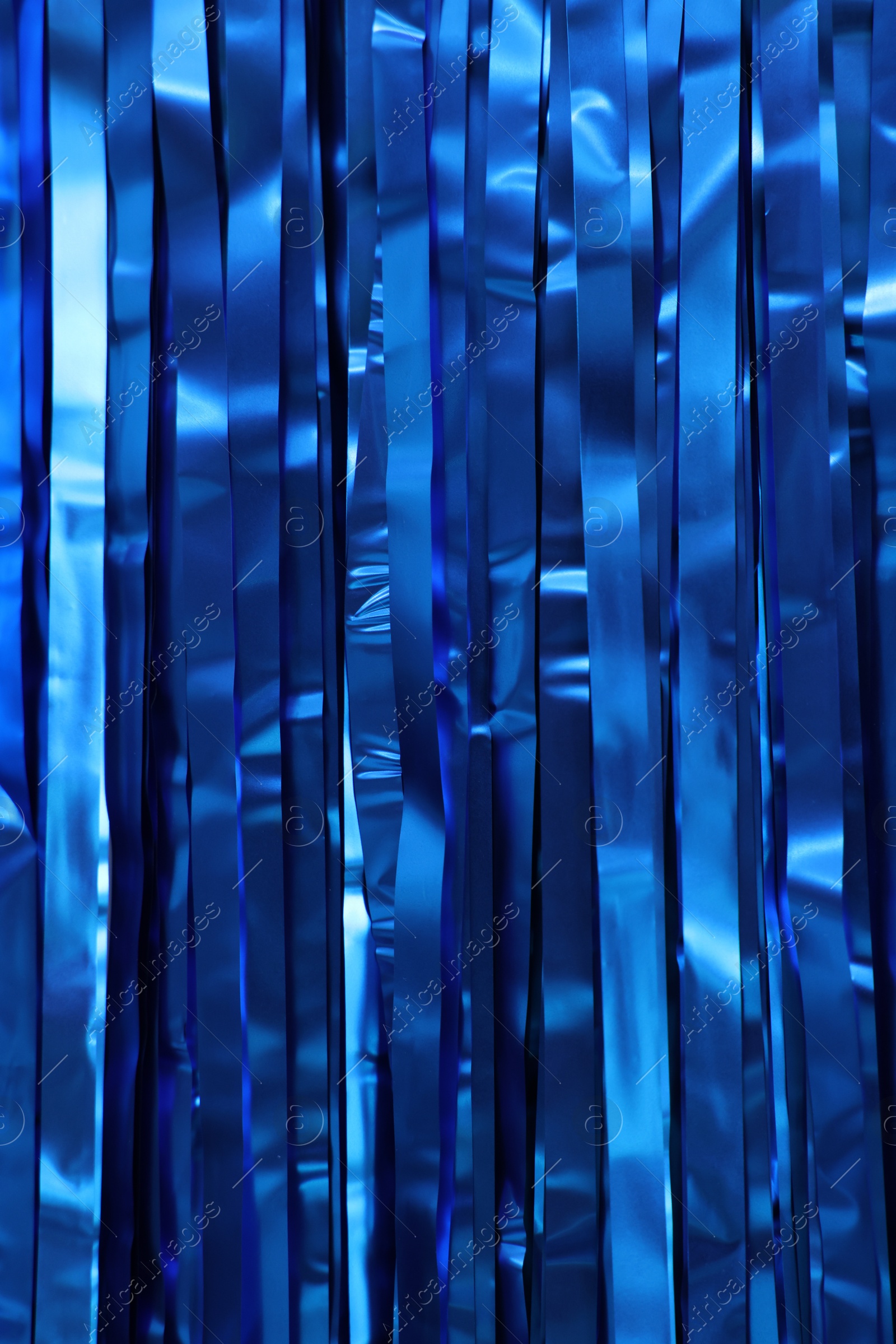 Photo of Shiny blue foil curtain as background, closeup