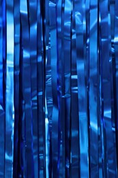 Photo of Shiny blue foil curtain as background, closeup