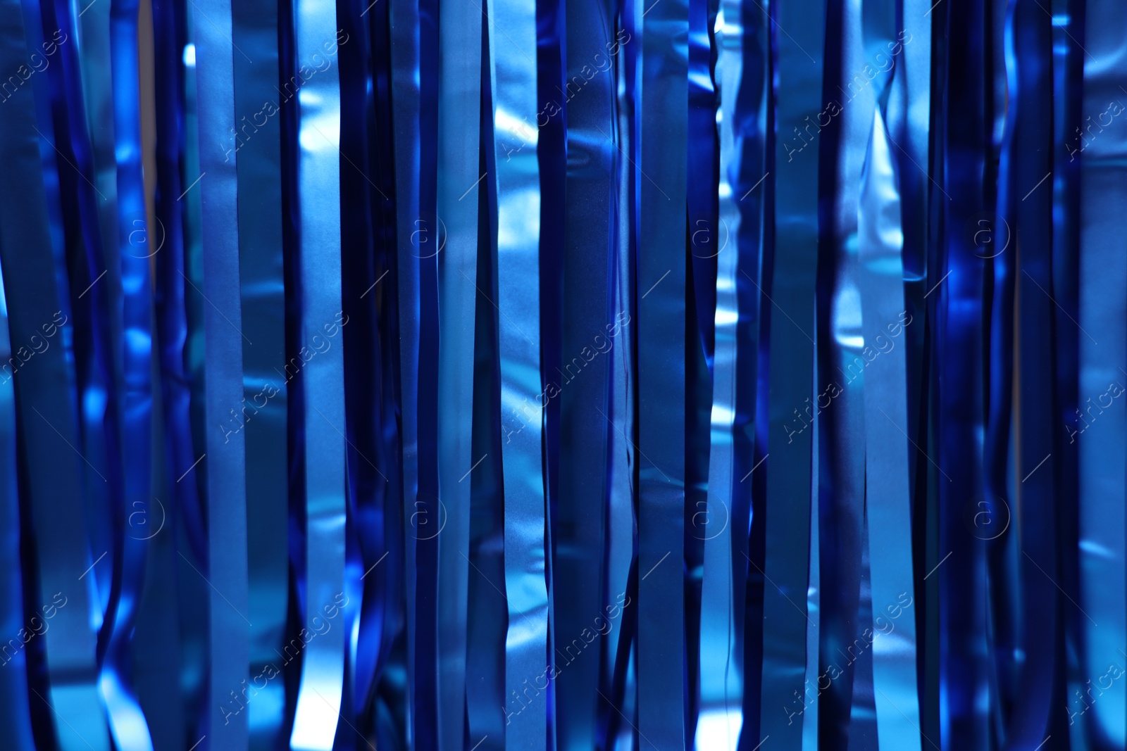 Photo of Shiny blue foil curtain as background, closeup