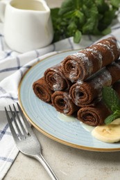 Photo of Delicious chocolate crepes with banana and blueberries served on light table, closeup