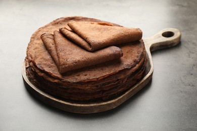 Photo of Stack of delicious chocolate crepes on grey table