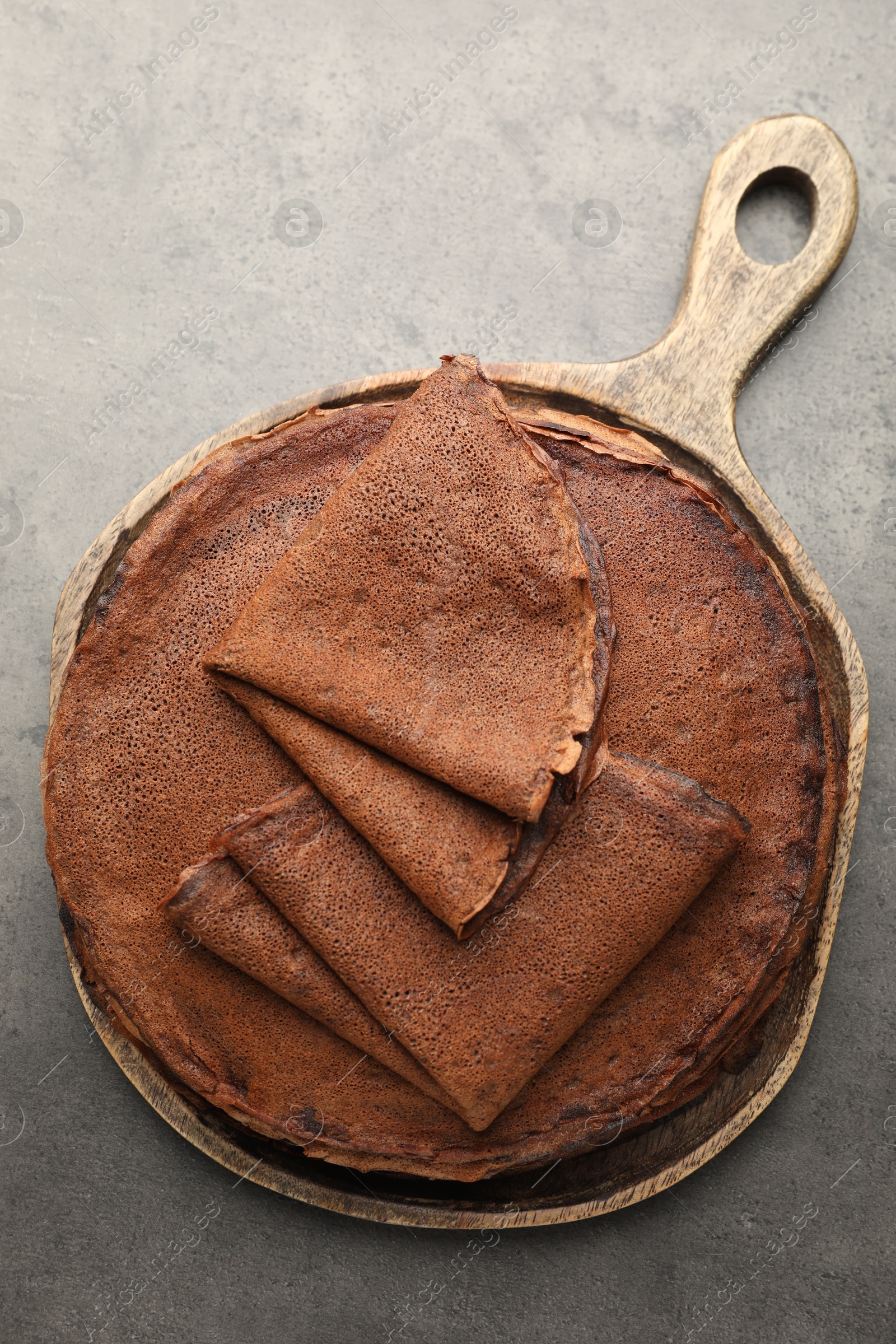 Photo of Delicious chocolate crepes on grey table, top view