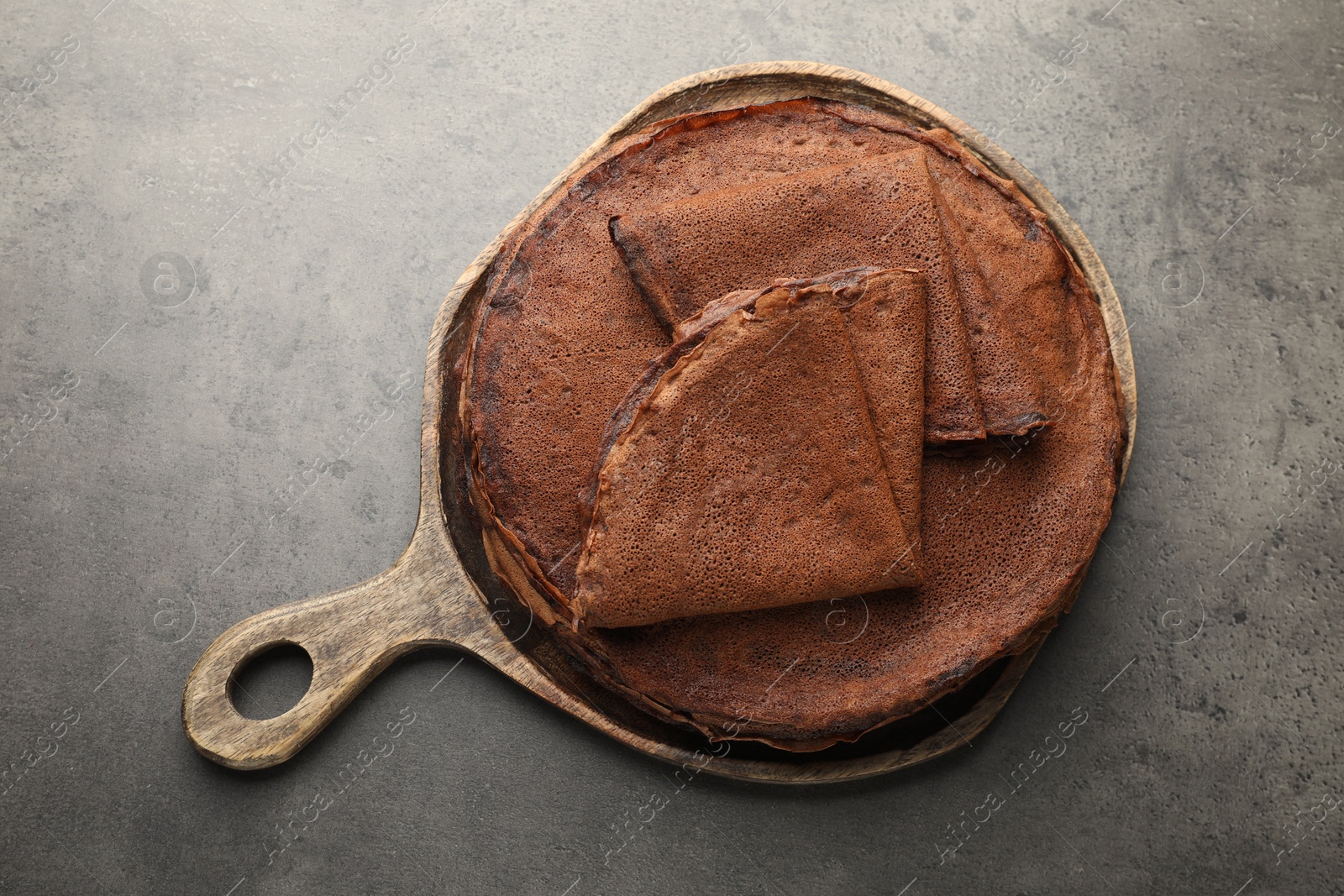 Photo of Delicious chocolate crepes on grey table, top view