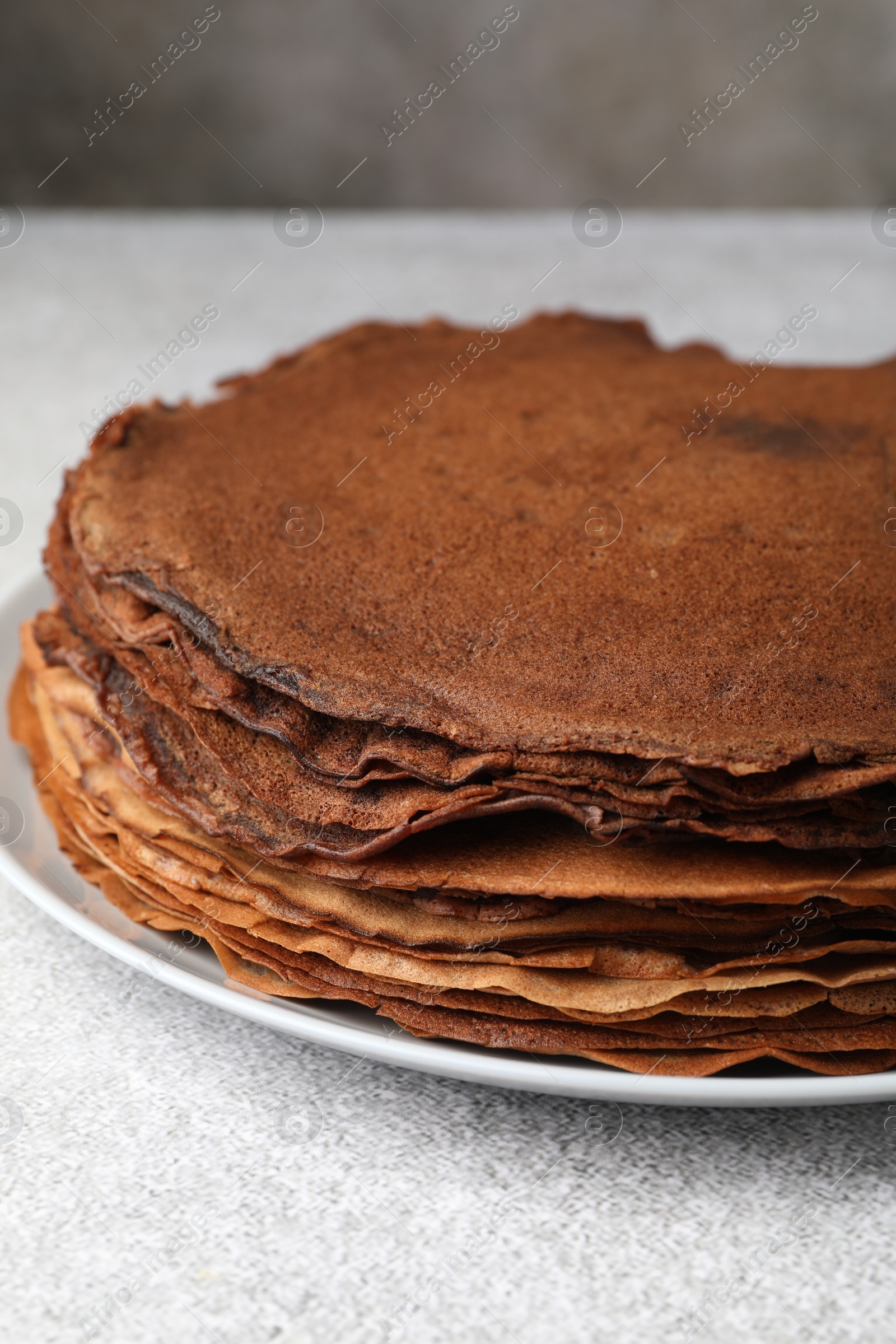 Photo of Delicious chocolate crepes on light grey table, closeup