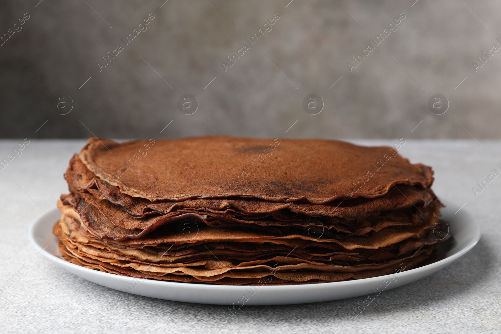 Photo of Delicious chocolate crepes on light grey table, closeup