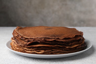 Photo of Delicious chocolate crepes on light grey table, closeup