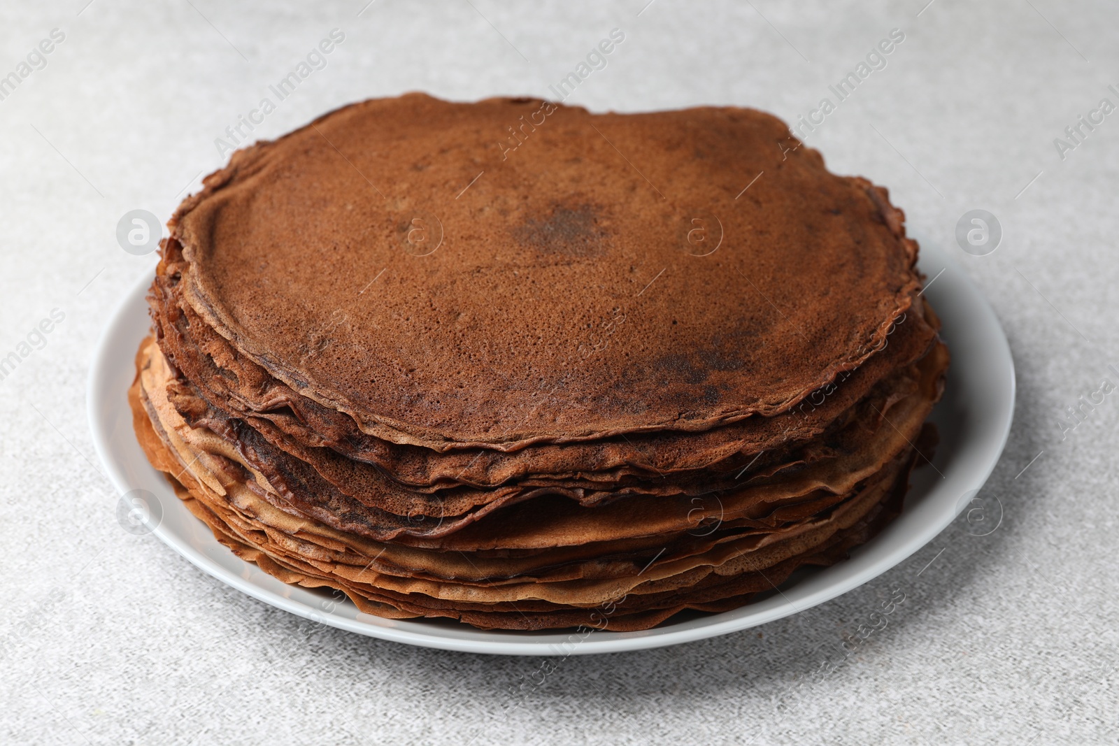 Photo of Delicious chocolate crepes on light grey table, closeup