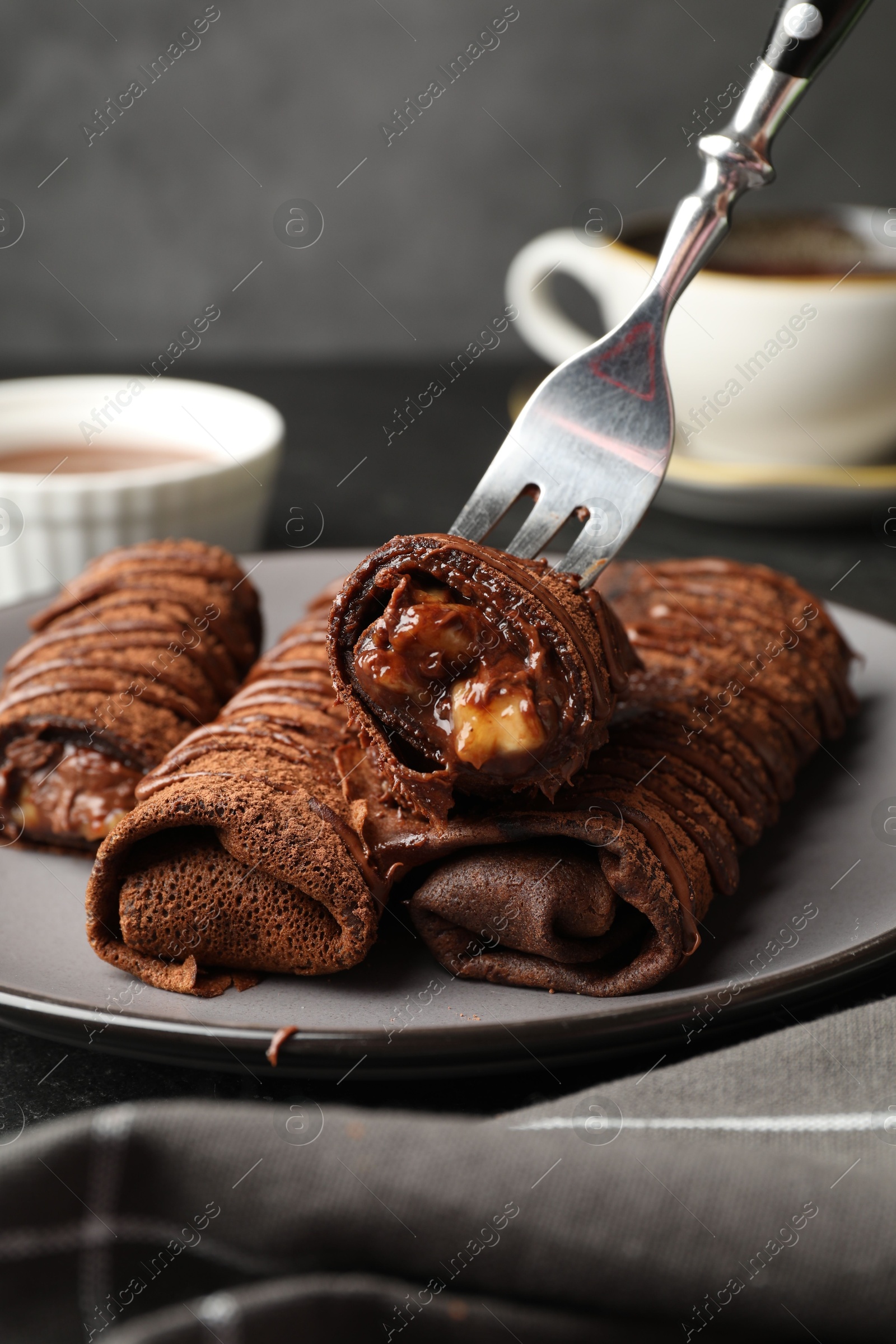 Photo of Delicious chocolate crepes with sweet paste and nuts on table, closeup