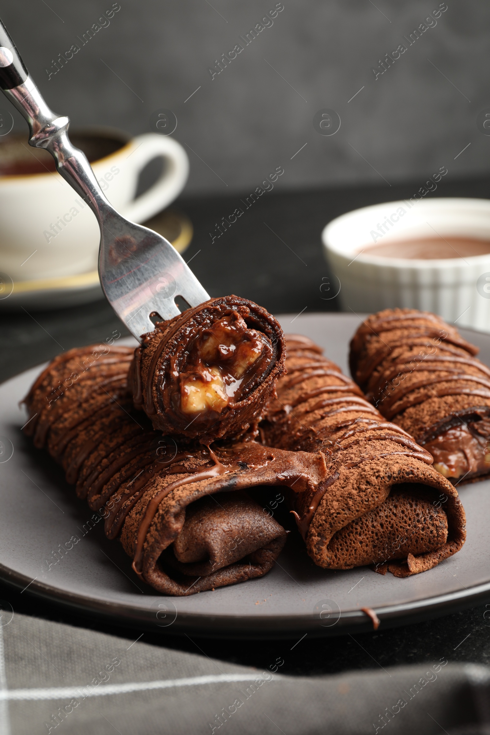 Photo of Delicious chocolate crepes with sweet paste and nuts on table, closeup