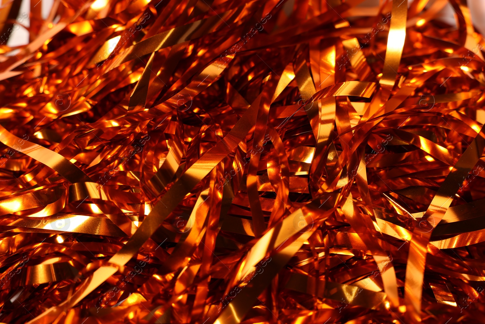 Photo of Shiny golden tinsel as background, closeup view