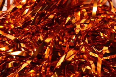 Photo of Shiny golden tinsel as background, closeup view