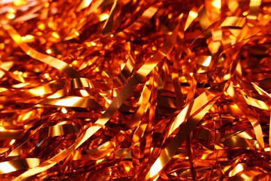 Photo of Shiny golden tinsel as background, closeup view