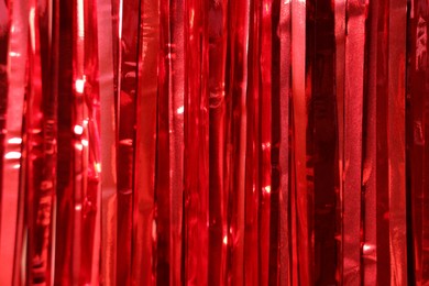 Photo of Shiny red foil curtain as background, closeup