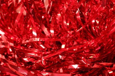 Photo of Shiny red tinsel as background, closeup view