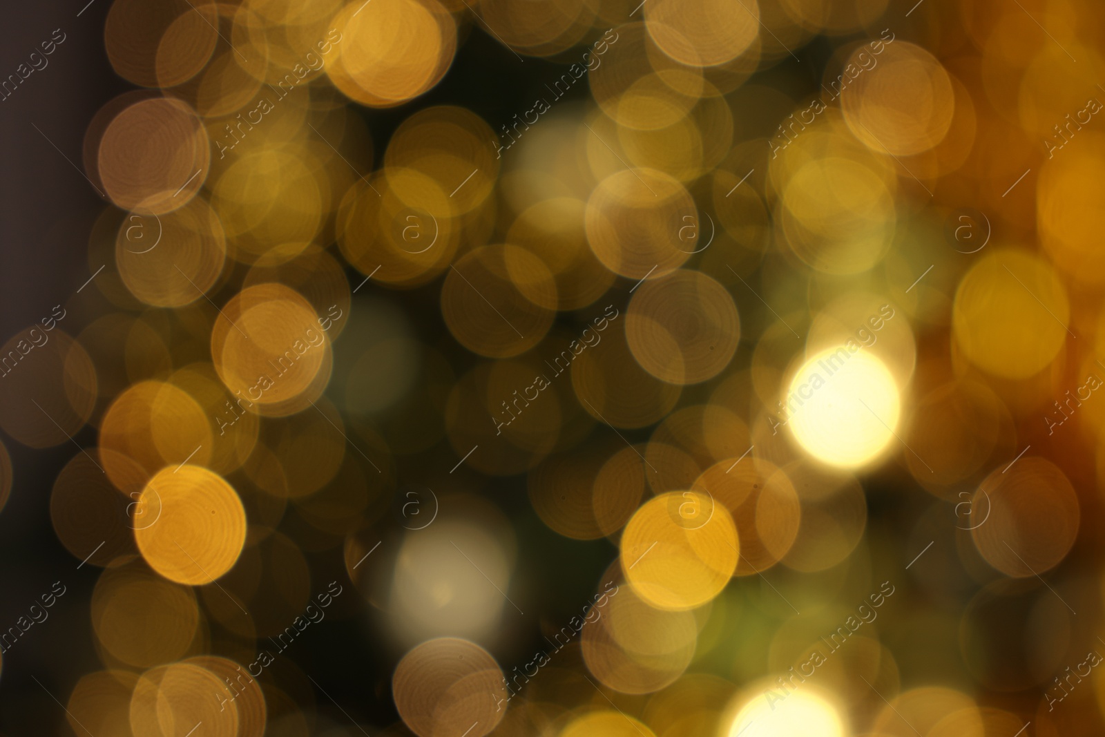 Photo of Blurred view of shiny golden lights as background. Bokeh effect