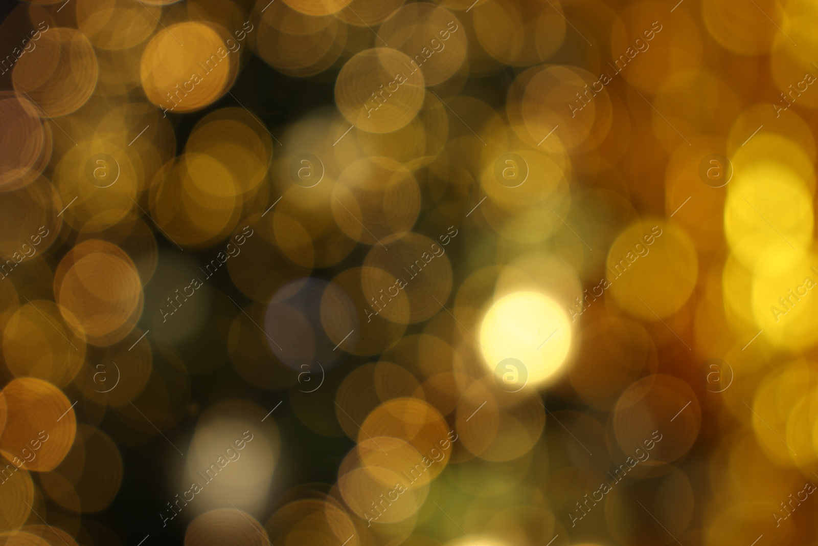 Photo of Blurred view of shiny golden lights as background. Bokeh effect