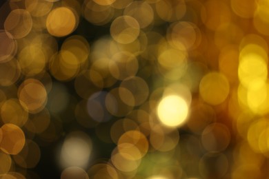 Photo of Blurred view of shiny golden lights as background. Bokeh effect