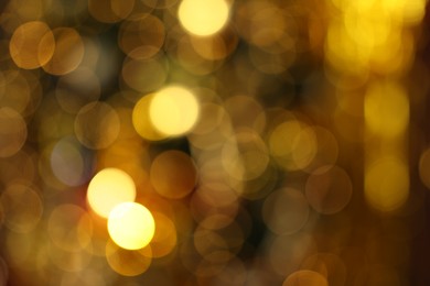 Blurred view of shiny golden lights as background. Bokeh effect