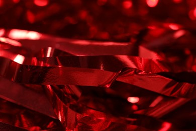 Photo of Shiny red tinsel as background, closeup view