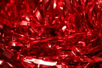 Photo of Shiny red tinsel as background, closeup view