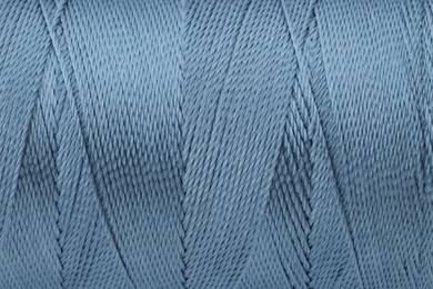 Photo of Beautiful blue sewing thread as background, closeup