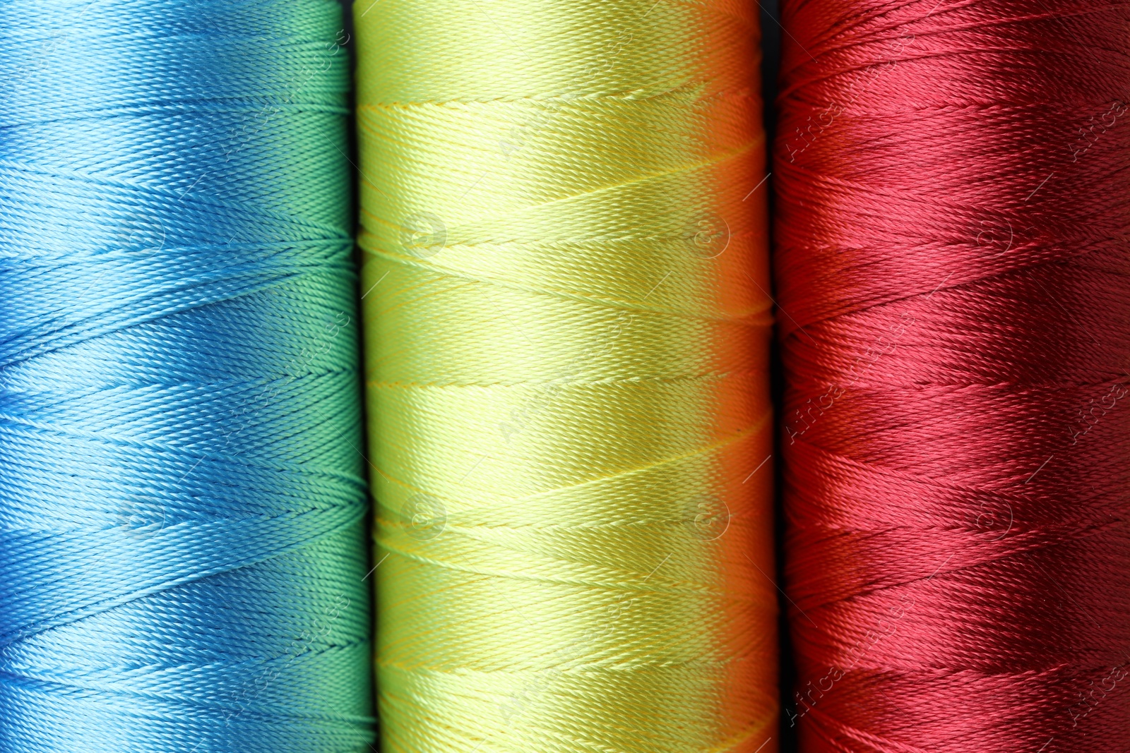 Photo of Spools of bright sewing threads as background, top view