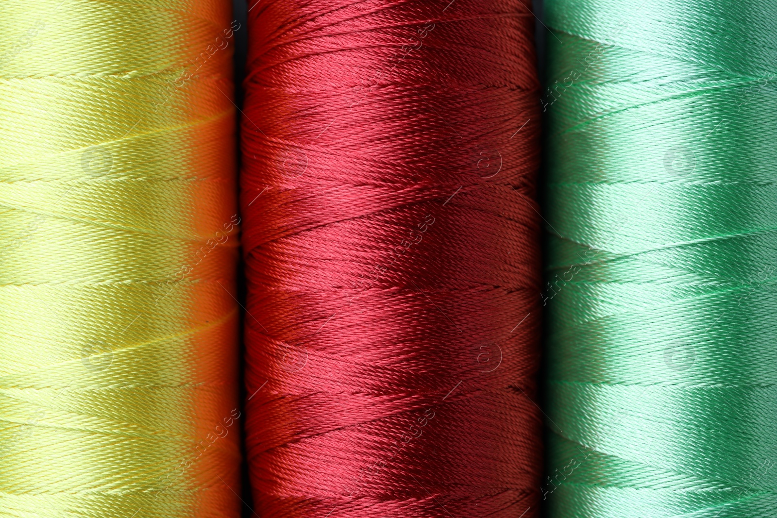 Photo of Spools of bright sewing threads as background, top view