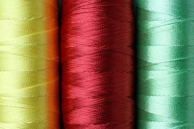 Photo of Spools of bright sewing threads as background, top view