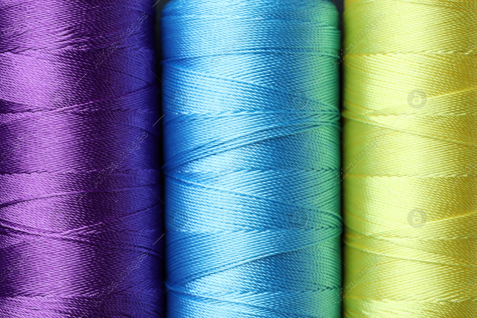 Photo of Spools of bright sewing threads as background, top view