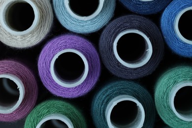 Photo of Spools of colorful sewing threads as background, top view