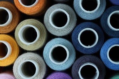 Photo of Spools of colorful sewing threads as background, top view