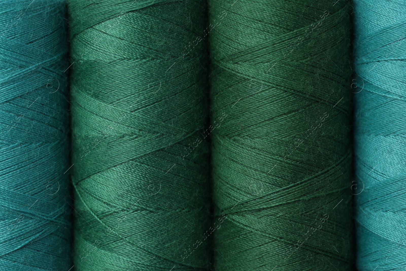 Photo of Spools of colorful sewing threads as background, top view