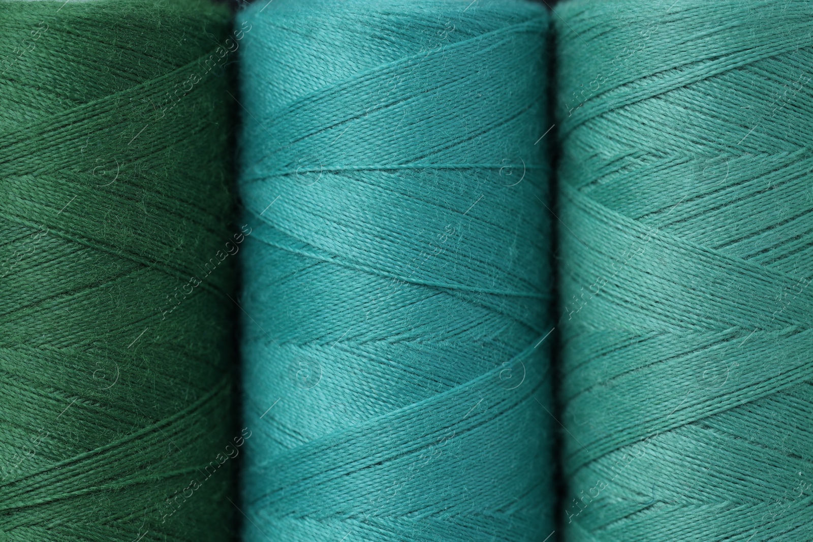 Photo of Spools of colorful sewing threads as background, top view