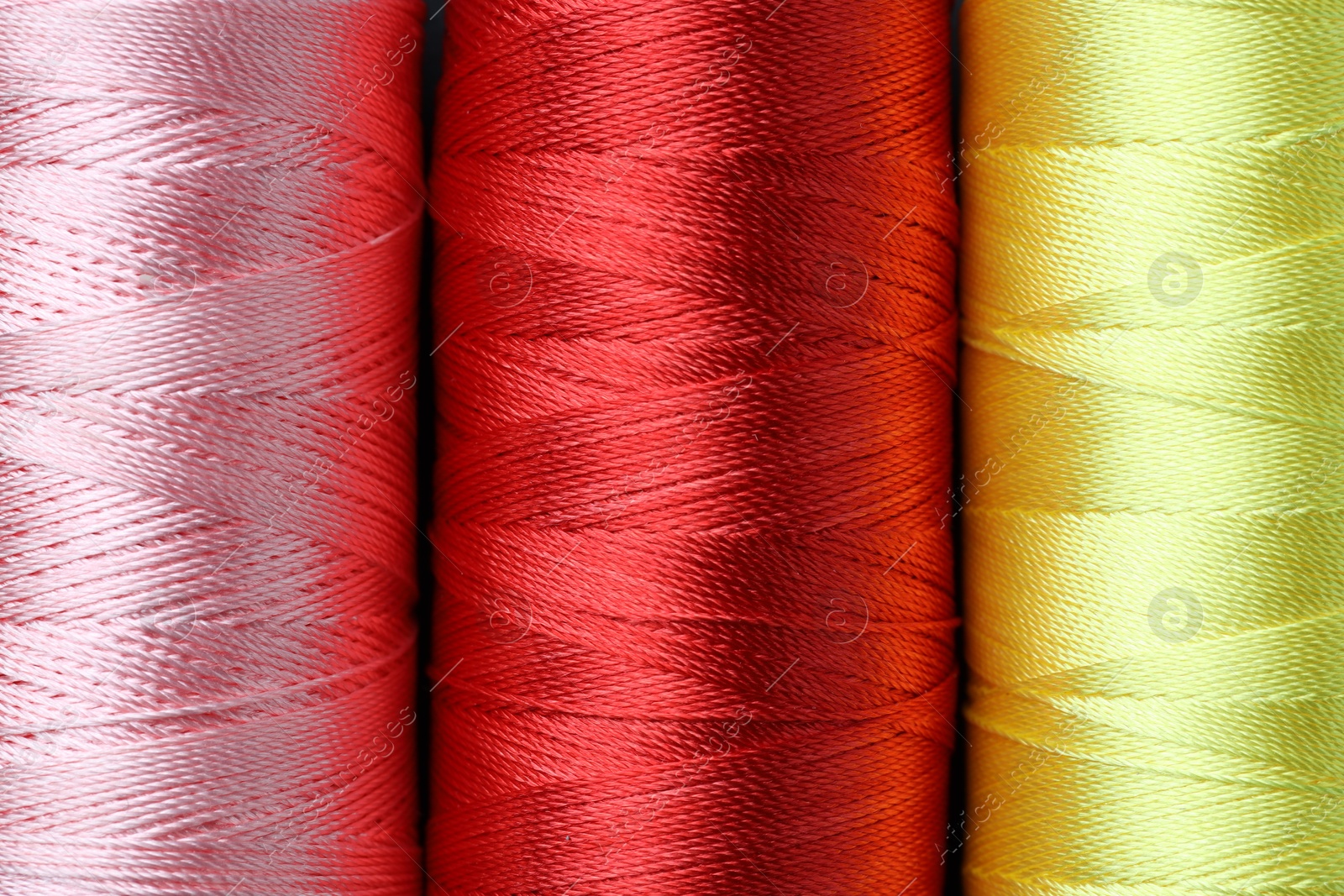 Photo of Spools of colorful sewing threads as background, top view